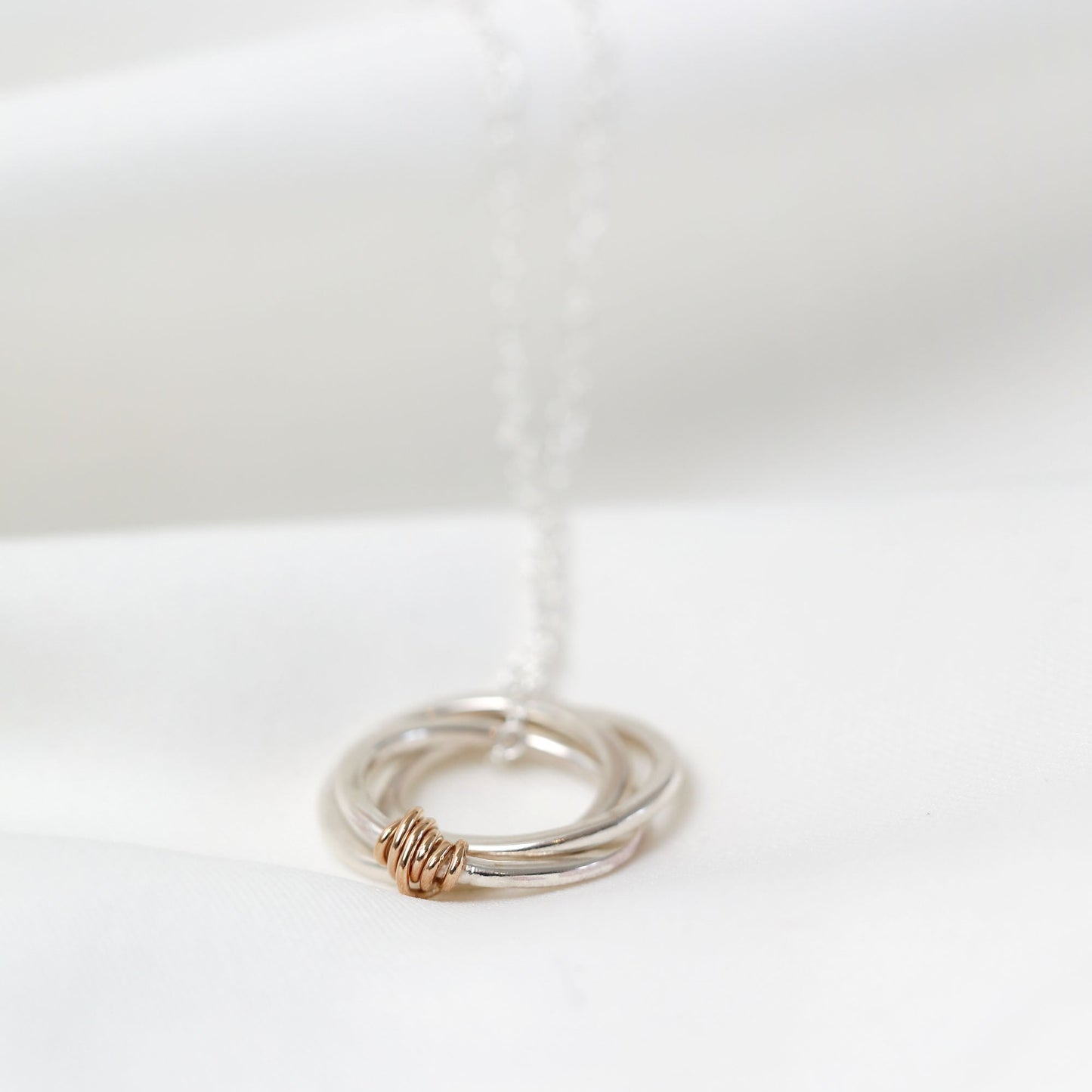 Three silver rings with a gold accent on a white background
