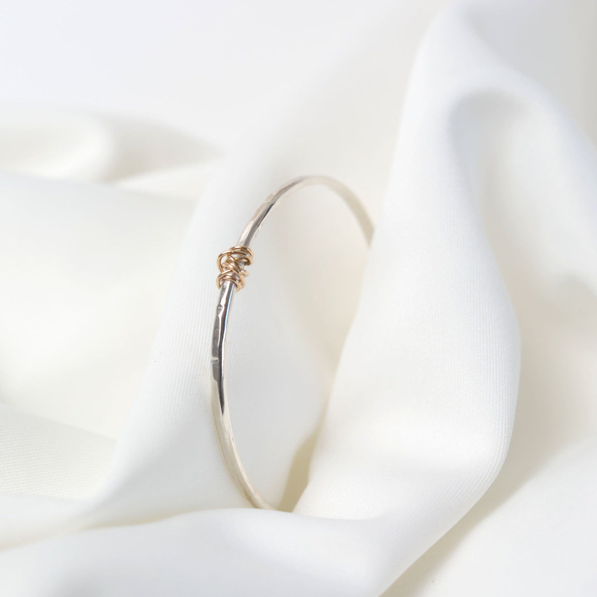 Gold hoop earring on a white fabric background